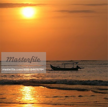 Drifting boat on a sunset. Coast of the Indian ocean. Bali