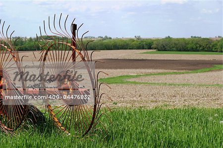 Farm equipment in SE Iowa fields - The hay rakes form windrows, gathering hay into rows for making bales.