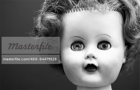 A black and white portrait of an old doll