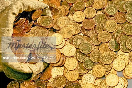 Bunch of golden coins scattered from sack