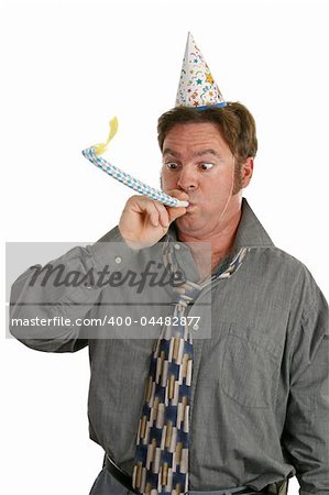 A man at a party, wearing a party hat and blowing a noisemaker.