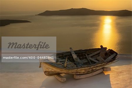 Old boat in sunset, view over the Caldera in Santorini, Greece