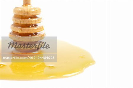 Honey and wooden drizzler, reflected on white background. Shallow DOF