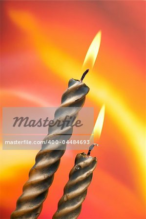 Two christmas candles over color background, vertical composition
