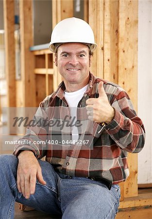 A handsome construction worker giving a thumbsup sign.  Authentic construction worker on actual construction site.