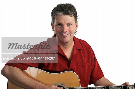 An attractive middle-aged guitarist jamming on an acoustic guitar.
