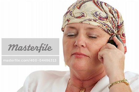 A woman, bald from chemotherapy, having a serious cell phone conversation.