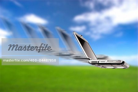 Laptop flying over a beautiful green meadow