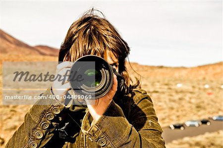 Brown haired woman taking picture.