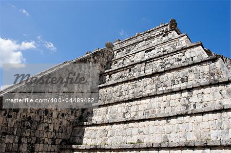 Wall of Ancient Mayan Pyramid at Chichen Itza on the blue sky. Chichen Itza in the Yucatan was a Maya city and one of the greatest religious center and remains today one of the most visited archaeological sites