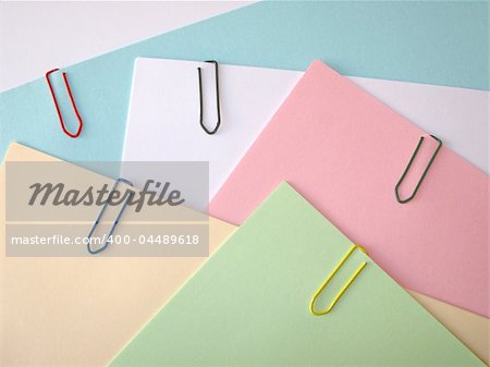 Stack of pastel papers attached with  paper clips