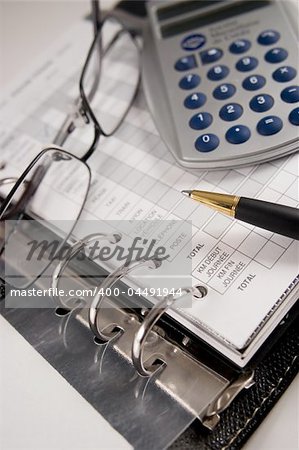 A calculator, a pen, glasses and a book