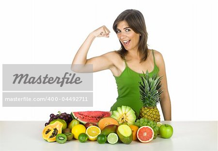 Beautiful and strong healthy woman with a lot of fruits in front of her