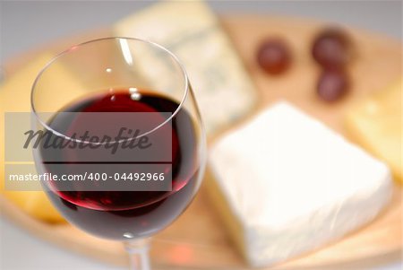 Glass of red wine and cheese plate