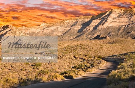 Road leading into Red Rock Canyon with blue sky.