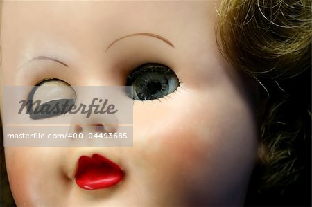 Close up of a doll face with one eye closed