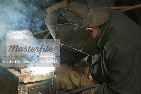 The worker is engaged in welding on a metal works