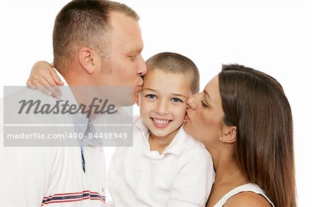 Adorable little boy getting kisses from his mother and father.  Isolated on white.