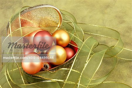 Christmas ornaments in a silver gift box surrounded by ribbon