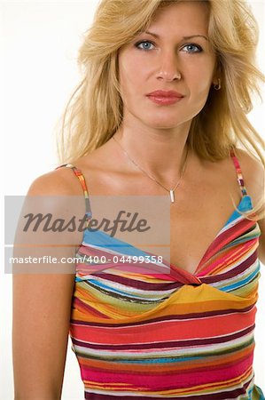 Attractive portrait of a woman with long blond hair and blue eyes with serious expression wearing a colorful striped top over white