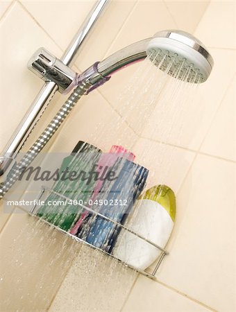 Showerhead in the bathroom with different color bottles