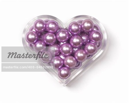 Heart-shaped plastic box with pink pearls in it.