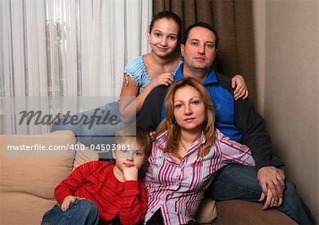 Mum, daddy and two children on a sofa