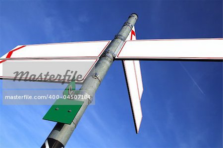 blank white direction boards with blue sky in the background