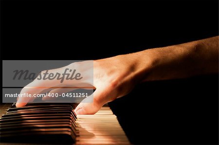 Caucasian male's hand playing the piano