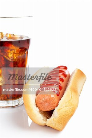 A hot dog and soda glass, reflected on white background. Shallow DOF