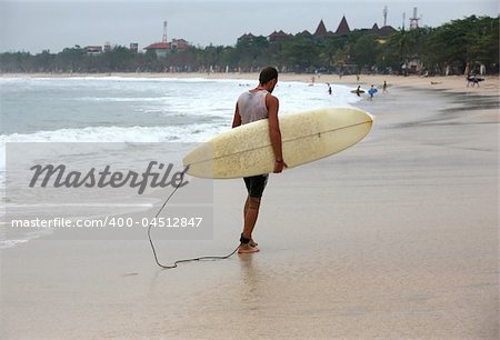 Lonely the man-surfer on a coastline. Bali