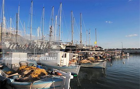 Image shows fishing boats moored in the marina of the city of Kalamata, Greece