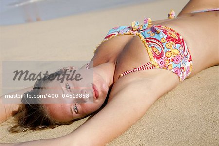 Pretty girl sunbathing on golden beach