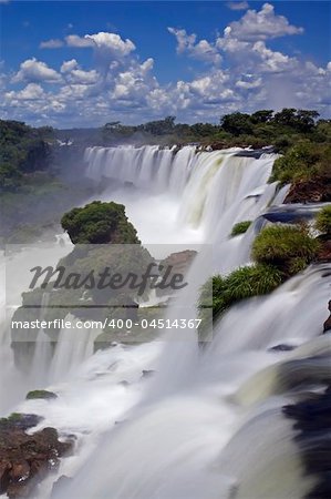 Iguassu Falls is the largest series of waterfalls on the planet, located in Brazil, Argentina, and Paraguay.  At some times during the year one can see as many as 275 separate waterfalls cascading along the edges of 2,700 meters (1.6 miles) cliffs. Argentines spells this wonder, ?Iguazu?, the Brazilians, ?Igaucu.? Both versions are globally correct and widely used. South America