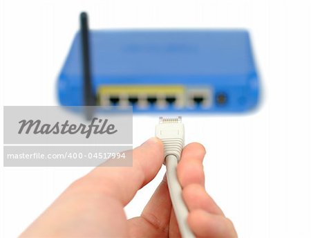 Male hand plugging connector into wireless router isolated over white