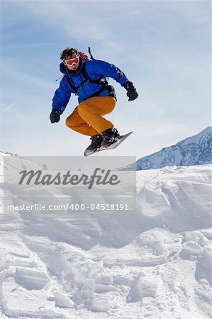 snowboarder taking jump in fresh snow