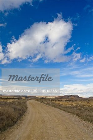 Lonely road to desert under cloudy sky