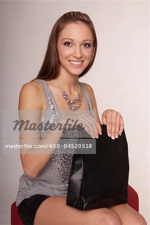sitting woman with long brown hair and black purchase bag