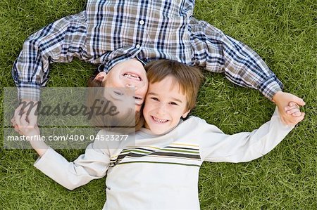 Brothers Holding Hands Laying in the Grass