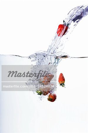 Fresh strawberries being poured in water