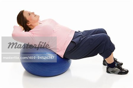 Beautiful plus-sized model doing pilates to tighten her abdominal muscles.  Full body isolated on white.