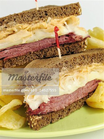 Reuben sandwich with corned beef, melted swiss cheese, sauerkraut, and thousand island dressing on pumpernickel rye bread. Served with potato chips.