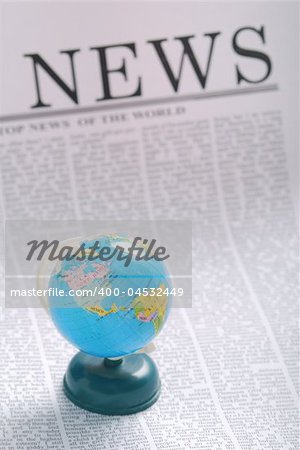global news concept. small globe on a newspaper page.