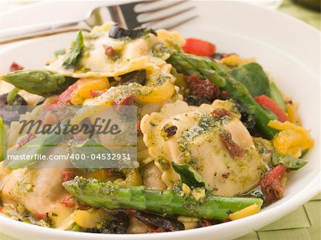 Plate of Roasted Vegetable Ravioli with Pesto Dressing Sun Blushed Tomatoes and Asparagus