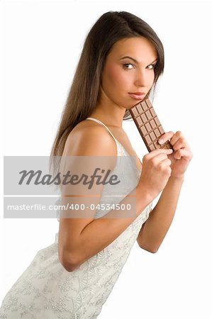 nice girl wearing a white dress and eating a block of chocolate