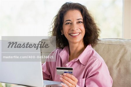Woman making online purchase at home looking to camera