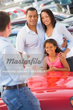 Young family collecting new car from salesman
