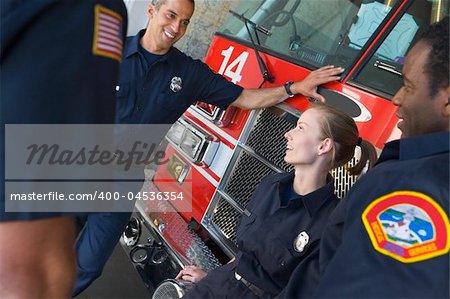 Firefighters chatting by a fire engine