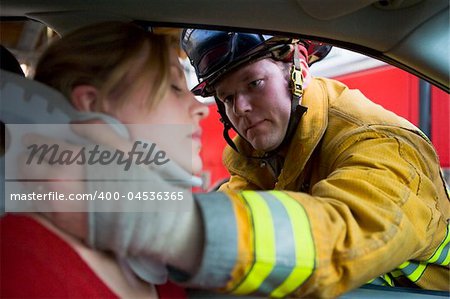 Firefighters helping an injured woman in a car