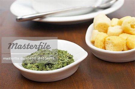 Parsley and bread croutons on wood background. Shallow depth of field